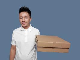 homme en portant papier carton Pizza boîte avec un main isolé sur plaine Contexte. photo