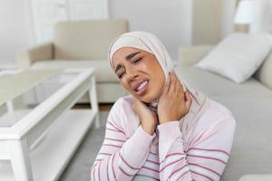 malheureux Jeune arabe musulman femme avec hijab Souffrance de douleur dans le cou photo