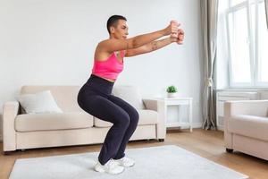 biceps des exercices, bras entraînement. sur de soi noir sportive Faire formation avec deux bleu haltères, bannière, flou Contexte. portrait de souriant fort en forme Dame dans blanc tenue de sport soutien-gorge Haut photo