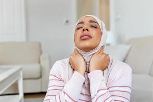 malheureux Jeune arabe musulman femme avec hijab Souffrance de douleur dans le cou photo