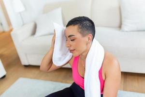 aptitude modèle. portrait de jolie souriant sportif noir femme dans tenue de sport ayant Pause après exercice avec serviette sur sa épaules, à la recherche loin, gratuit copie espace photo