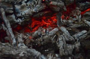 embrasé braise dans chaud rouge couleur. le chaud braise dans le milieu de brûlé bois journaux. bois de chauffage brûlant sur gril. la nature texture. photo