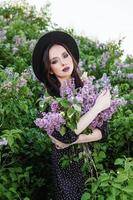 une à la mode fille avec foncé cheveux, une printemps portrait dans lilas tons dans été. brillant professionnel se maquiller. photo