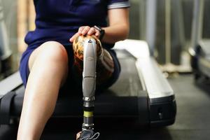 Jeune femelle avec un prothétique jambe avec le entraine toi de en utilisant prothétique jambes à marcher, exercice et et du quotidien Activités photo