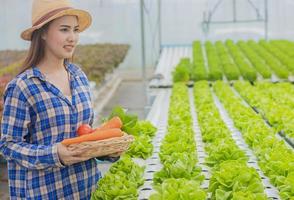 Portrait d'une femme asiatique tenant un panier de légumes frais photo