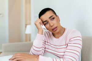 jeune femme malheureuse couvrant le visage avec les mains, pleurant seule en gros plan, fille déprimée assise sur un canapé à la maison, problème de santé ou pensant à de mauvaises relations, rompre avec son petit ami, divorcer photo