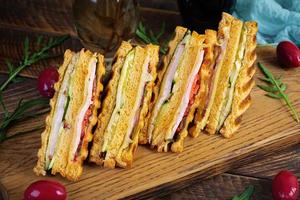club sandwich avec jambon, fromage, tomate et salade. grillé sandwich avec séché tomates pain photo
