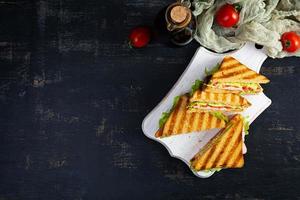 club sandwich avec jambon, tomate, vert et fromage. grillé panini. Haut vue photo