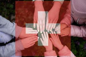 mains de des gamins sur Contexte de Suisse drapeau. Suisse patriotisme et unité concept. photo