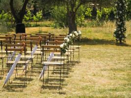 mariage cambre décoré avec tissu et fleurs en plein air. magnifique mariage ensemble en haut. mariage la cérémonie sur vert pelouse dans le jardin. partie de le de fête décor et floral arrangement. photo