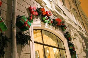 branches de sapin de noël élégantes avec boules et coffrets cadeaux devant la porte au marché de vacances ou au restaurant dans la rue de la ville. décor de rue de Noël d'hiver photo