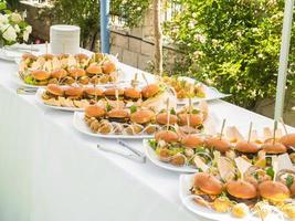 banquet table avec collations nourriture sur assiettes Hamburger fête dîner table - buffet table après mariage la cérémonie photo