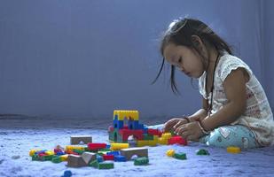 asiatique femme construit une maison de Plastique blocs le concept de promouvoir le développement de Jardin d'enfants les enfants. photo