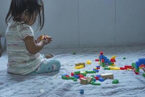 asiatique femme construit une maison de Plastique blocs le concept de promouvoir le développement de Jardin d'enfants les enfants. photo