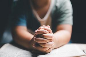 peu garçon prier à Dieu avec mains tenue ensemble. enfant culte à Dieu. mignonne peu garçon dans une Christian famille. photo