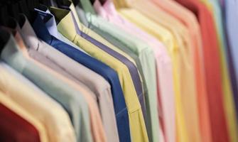 Close up de chemises multicolores sur cintres