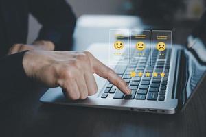 homme d'affaires appuyant sur le sourire sur le service client du clavier d'ordinateur portable, concept d'évaluation, évaluation de l'expérience de service sur l'application en ligne, enquête de satisfaction des clients, commentaires négatifs photo