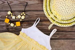 été enfants Vêtements robe, chapeau et perles sur en bois Contexte. tonique image. photo