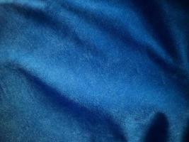 texture de tissu de velours bleu utilisée comme arrière-plan. fond de tissu bleu vide de matière textile douce et lisse. il y a de l'espace pour le texte. photo