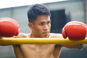 muay thaïlandais, le martial art de Thaïlande, boxeur séance dans le coin lorsque le arbitre s'arrête le bats toi dans chaque rond pour le boxeur à du repos et le entraîneur à présenter le bats toi dans le suivant rond. photo