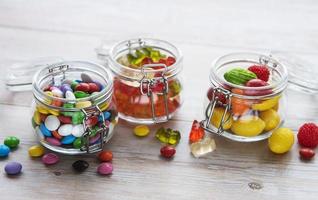 Bonbons colorés en pots sur table photo