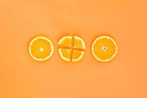 trois tranches d'orange sur fond orange