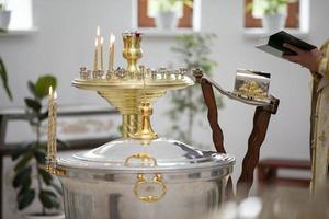 le intérieur de le église pendant le Baptême de une enfant. une baignoire pour Baptême. photo