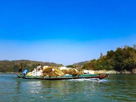 une bateau plein de riz céréales est porter grand récolté riz photo