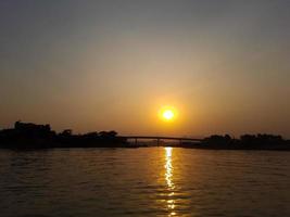 le couchers de soleil plus de le rivière comme vu de le bateau. photo