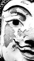 proche en haut moitié visage de pierre Bouddha statue cassé, blessé ou endommagé dans noir et blanc style à temple. art et religion dans monochrome Ton concept photo