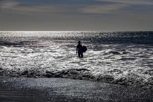 surfeur sur une Contexte de rugueux océans sur une chaud ensoleillé été jour, photo