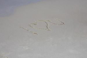 une inscription sur le le sable sur le mer rive je l'amour vous photo