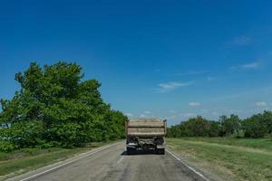 Vieux camion roule sur une route goudronnée cassée en arrière-plan de la nature photo
