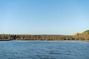 paysage naturel avec un lac et des arbres d'automne sur la rive.