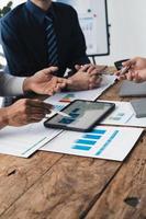 groupe de Jeune affaires gens travail et communicant tandis que séance à le Bureau bureau ensemble, en utilisant tablette à présent leur concept. photo