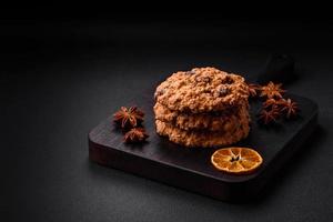 délicieux cuit flocons d'avoine raisin biscuits sur une foncé béton Contexte photo