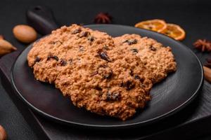 délicieux cuit flocons d'avoine raisin biscuits sur une foncé béton Contexte photo