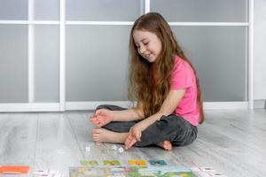 peu content fille sur le sol jette Jeu dé pour planche jeu, Passe-temps photo