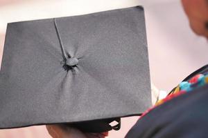 les étudiants tiennent des chapeaux à la main pendant le succès du début sur fond jaune photo