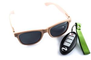 rose des lunettes de soleil avec voiture clés sur blanc Contexte photo