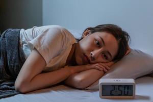 triste inquiet et stressé, asiatique Jeune beau, jolie femme, fille Souffrance de insomnie, éveillé dans le nuit dans chambre à coucher, fatigué et épuisé. frustré gens avec problème, épuisé sur cauchemars photo