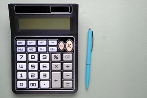 calculatrice avec un stylo à bille sur un fond de texture en cuir. photo