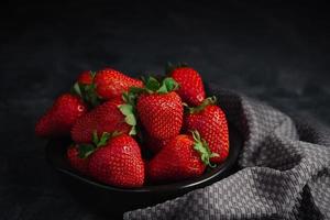 fraise avec gris serviette de table sur noir Contexte. sucré couleurs photo