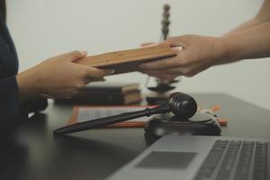 marteau de juge avec des avocats de la justice ayant une réunion d'équipe au fond d'un cabinet d'avocats. notions de droit et de services juridiques. photo