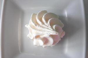 petit blanc savoureux sucré Meringue sur une blanc assiette photo