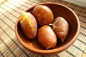 bol et panier avec Jeune Patate sur en bois arrière-plan, Haut vue photo