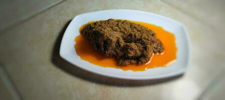 portion rendang Viande sur une blanc assiette photo