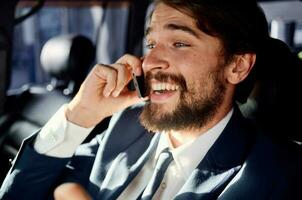affaires homme avec une barbe parlant sur le téléphone dans une voiture voyage photo
