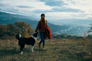 femmes en marchant suivant à le chien dans la nature paysage montagnes Voyage photo