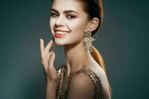de bonne humeur femme dans une d'or robe bijoux des boucles d'oreilles mode charme photo
